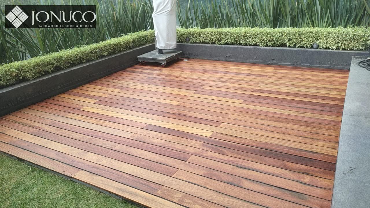 Terraza de madera cumarú con jardineras y vegetación